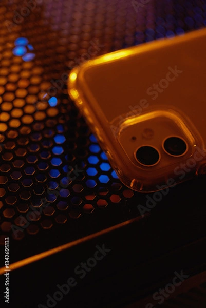 Fototapeta Smartphone at night on a technological table with neon lights.
