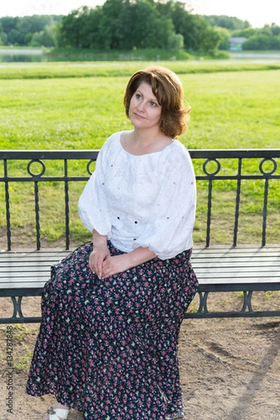 Obraz woman sitting on bench in summer park
