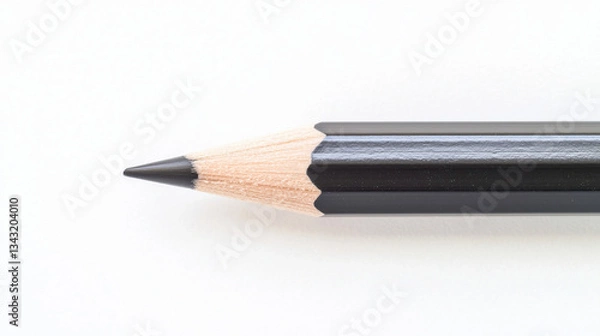 Obraz Close-up of a sharpened pencil with a black tip against a white background.