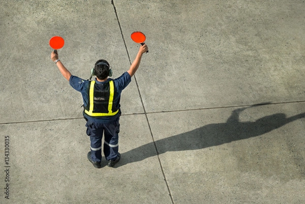Fototapeta Airport worker directing