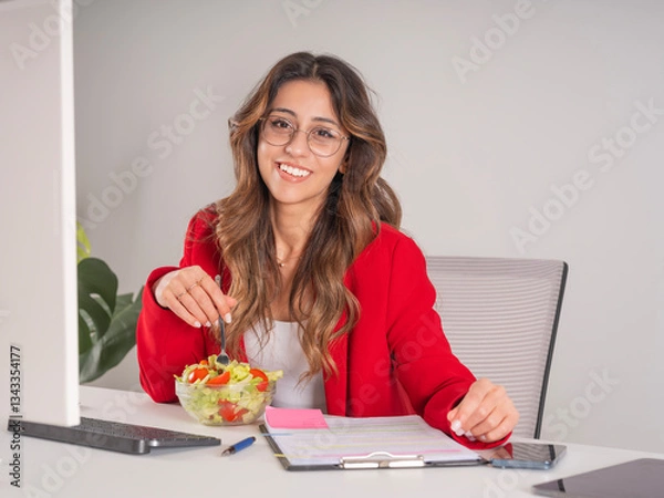 Fototapeta Eating healthy salad in office, portrait of young caucasian fit beautiful businesswoman eating healthy salad in office. Lunch break at workplace modern lifestyle concept idea image, copy space.