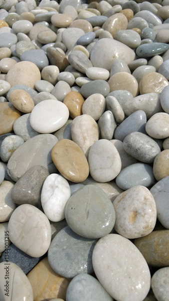 Obraz Smooth pebbles on beach, natural colors and textures, vertical close-up, phone wallpaper
