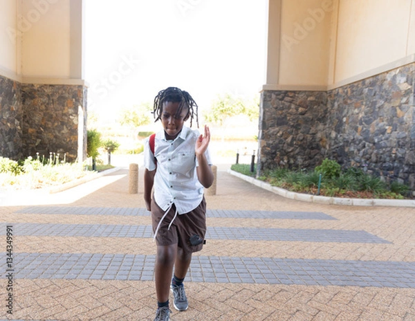 Fototapeta Walking confidently outside school, student in casual clothes with backpack, copy space