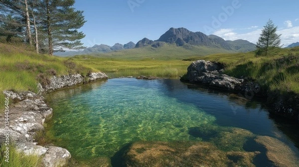 Fototapeta Crystal-clear pool in Scottish highlands, surrounded by rocks, heather, and majestic mountains under a sunny sky.