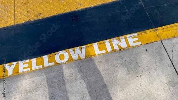 Fototapeta Angle looking down at yellow safety line on railway platform, creating abstract composition
