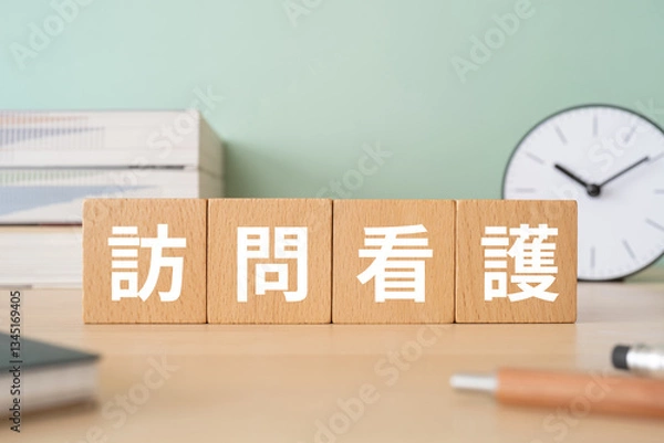 Obraz 訪問看護と書かれたブロックが置かれたデスク仕事
