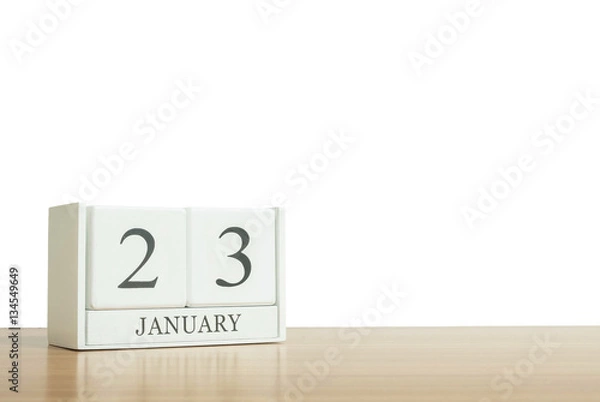 Fototapeta Closeup surface white wooden calendar with black 23 january word on blurred brown wood desk isolated on white background with copy space , selective focus at the calendar
