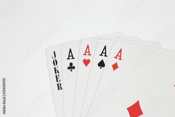 Fototapeta Playing cards - four aces and joker close up isolated in studio.