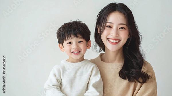 Fototapeta Studio Portrait of a Happy Asian Mother and Daughter: A Family Concept Featuring a Japanese Young Mother and Her Cute Son Interacting and Smiling in Front of a Plain White Background