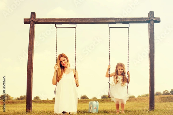 Obraz Mother and her daughter enjoy summer sunset on swing