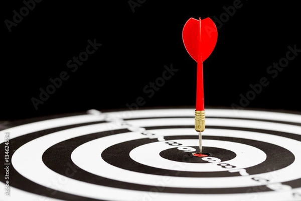 Fototapeta Target dart arrow hitting in the center of dartboard