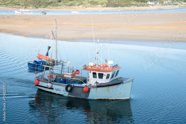 Fototapeta Fishing boat arrives in the port of Padstow at the Camel estuary in north Cornwall.