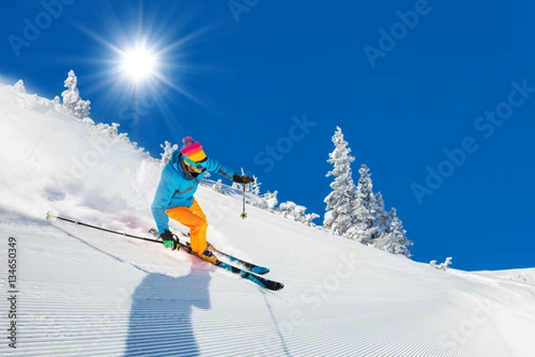 Obraz Skier on piste running downhill