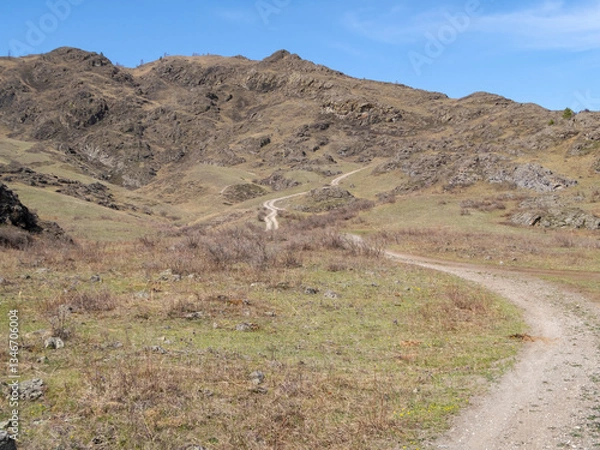 Obraz A country road meanders up into the mountains in the Altai Mountains in spring