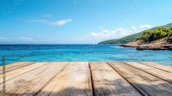 Fototapeta A wooden table set against a stunning background of the sea, island, and clear blue sky, showcasing the serenity of a coastal escape.