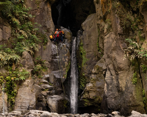 Obraz Group rappelling down a waterfall in Salto do Cabrito. Sao Miguel island in the Azores.