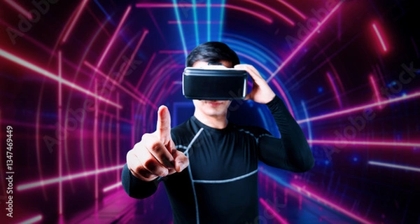 Fototapeta Professional male gamer with VR glasses pointing and playing game with glowing neon light. Excited player enjoy connecting in metaverse while using augmented reality technology innovation. Ingenuity.