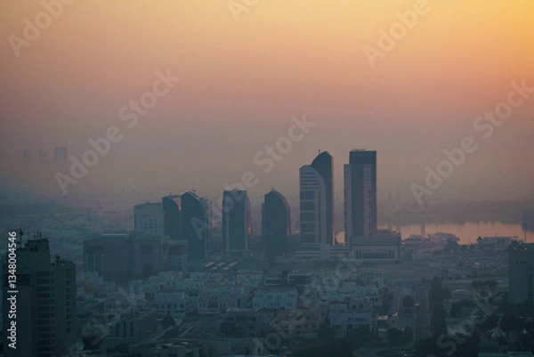 Fototapeta Aerial view of Abu Dhabi in the morning light, as the rising sun casts a golden glow over the city's modern skyline.