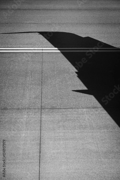 Fototapeta Silhouette of an airplane wing on the runway