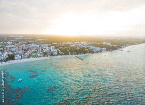 Obraz A beautiful blue ocean with a white sandy beach and a city in the background