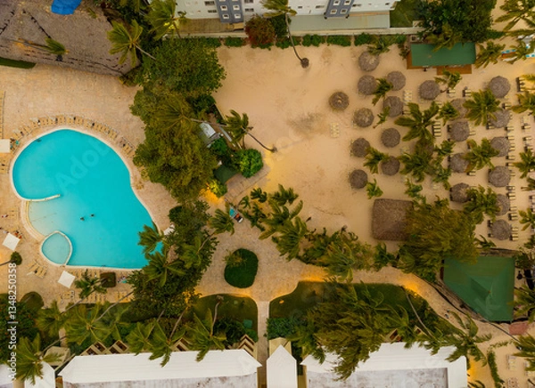 Obraz A pool and a beach area with palm trees