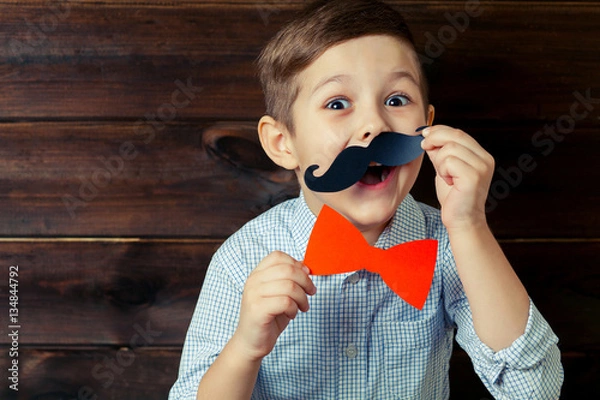 Fototapeta A kid with props for a photo booth. Surprised child with the req