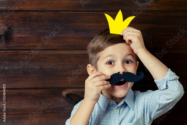 Fototapeta A kid with props for a photo booth. A child with the requisite m