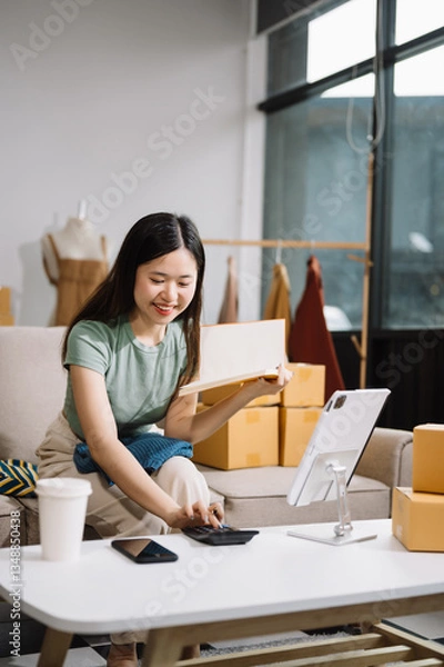 Fototapeta Startup small business SME, Entrepreneur owner woman using smartphone or tablet taking receive and checking online purchase shopping order