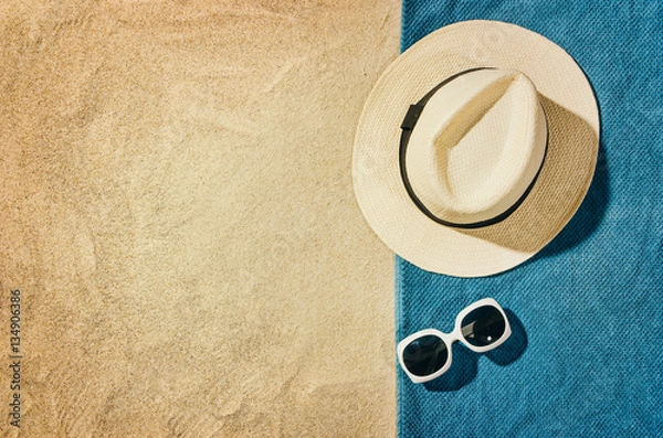 Obraz Top view of sandy beach with towel frame and summer accessories. Background with copy space and visible sand texture. Right border made of towel
