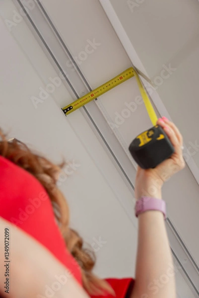 Fototapeta The designer measures the size of the portal for the curtain rod with a tape measure