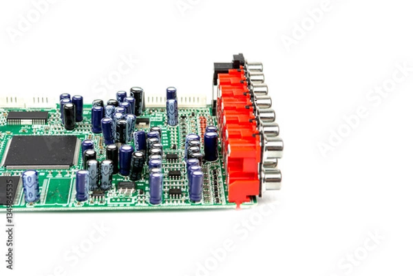 Fototapeta A close-up of the processor microchip surrounded by other electrical components on a green circuit board. Also on the board is a row of several speaker connectors.