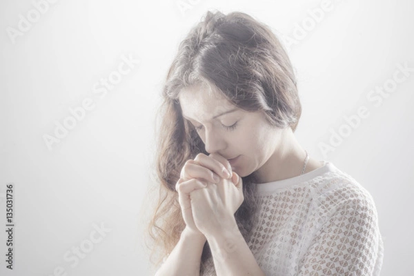 Obraz Praying woman on white background with shine.