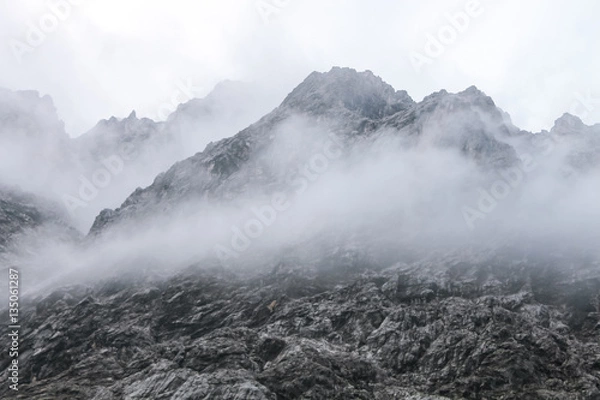 Obraz hiding peak minimal mountain shape fog and clouds move black triangle Alps Bavaria Germany near Zugspitze highest point
