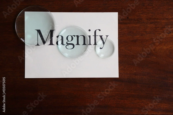 Fototapeta Magnify broad text on white sheet with glass lenses on antique desk 