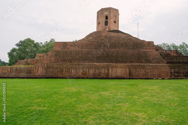 Fototapeta An ancient brick stupa in Varanasi, India, stands as a historic Buddhist monument, surrounded by greenery, symbolizing spiritual and historical significance.