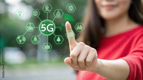 Obraz 5G network. Woman in red sweater interacts with a futuristic green holographic interface showcasing 5G network technology icons in an outdoor