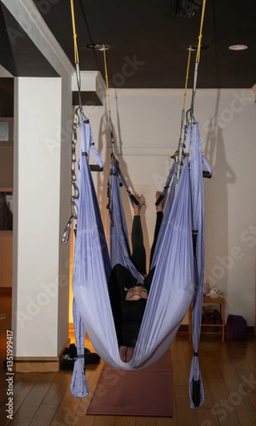 Fototapeta Woman relaxing in aerial yoga class