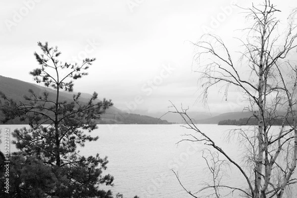Obraz Landscape with a huge lake with Norwegian mountain fjords visible in the distance on a foggy autumn day.