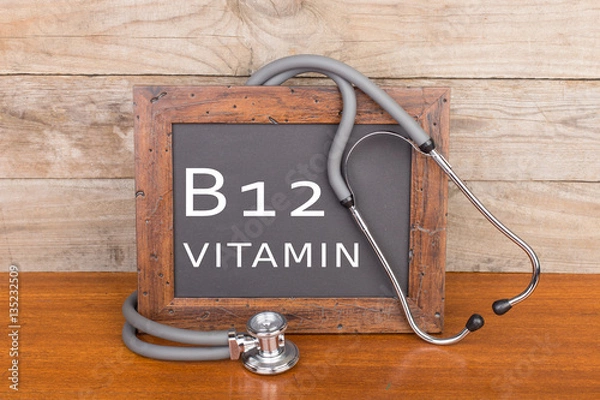 Fototapeta stethoscope and blackboard with text "Vitamin B12" on wooden background