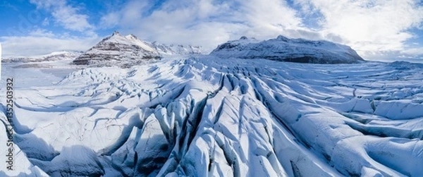 Fototapeta Aerial view of glacier from above, ice texture landscape, beautiful nature blue background from Vatnajokull, Iceland.
White and blue ice texture. Melting glaciers, global warming. Sunny day 