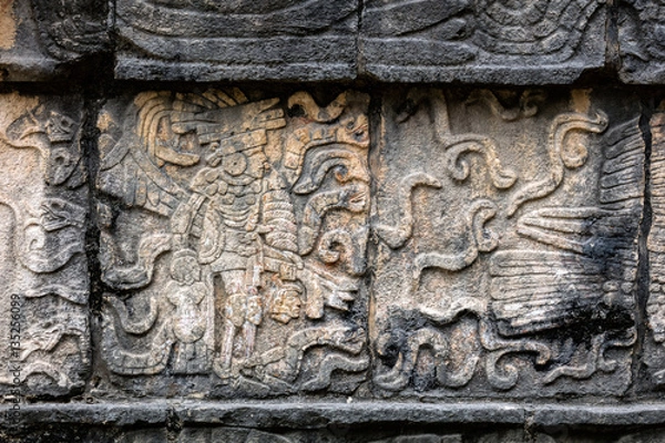 Fototapeta Ancient Mayan mural depicting a warrior holding a human head on the Platform of the Skulls, a.k.a. Tzompantli in Chichen Itza, Yucatan, Mexico