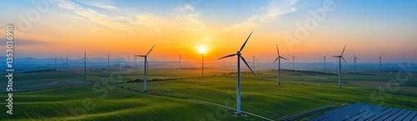 Fototapeta Wind turbines in a field during a vibrant sunset scene