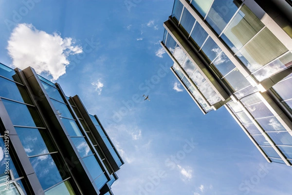 Obraz an airplane between two office buildings