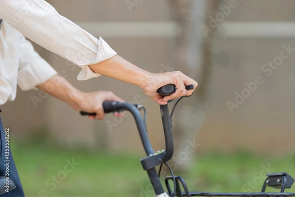 Fototapeta Bicycle Handling and Awareness. Close-up of hands on bicycle handlebars, emphasizing control and safety.