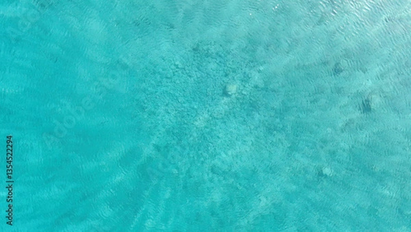 Fototapeta A mesmerizing aerial shot of crystal-clear turquoise waters, revealing the underwater textures beneath. Perfect for backgrounds, nature themes, and travel-related designs.