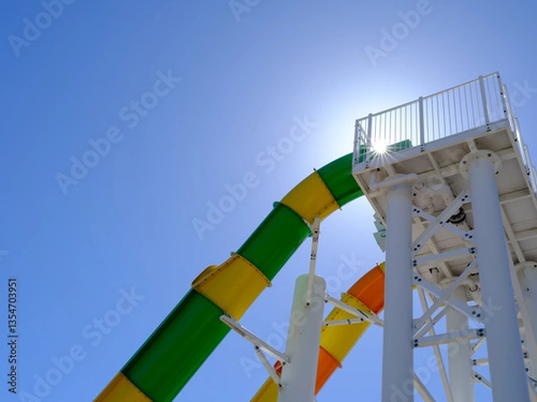 Obraz Abstract Graphic resource image of the bright colors of a tall water slide and star burst over the railing against a perfect blue sky in Virginia
