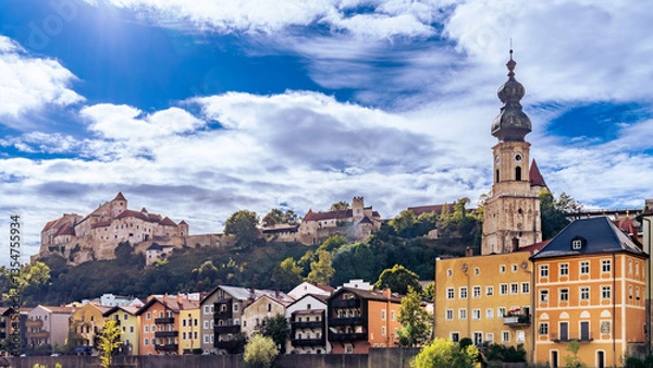 Fototapeta Skyline der Stadt Burghausen an der Salzach mit Burganlage unter weiß-blauem Himmel 