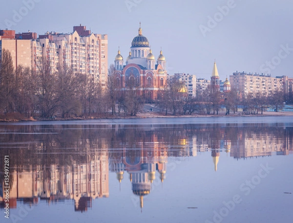Fototapeta Golden sunrise bathes Obolon Embankment in Kyiv, painting the river in soft hues. A majestic church with shining domes rises among tranquil waters, its reflection a perfect mirror of morning serenity 