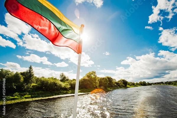 Obraz Lithuanian flag on boat while traveling by the river