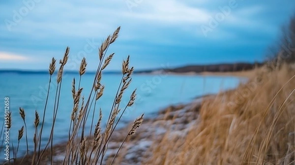 Fototapeta Peaceful lakeside scene with golden grass swaying in the wind under a cloudy sky : Generative AI